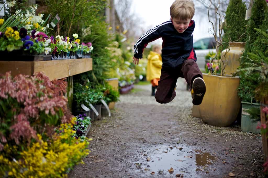 A child jumping a puddle